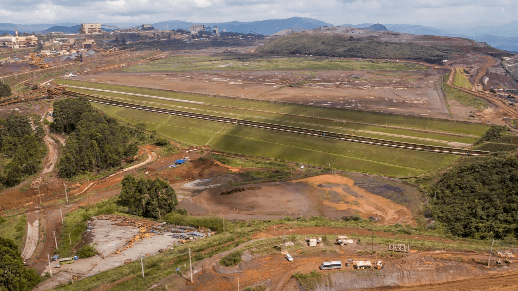 Aerial view of a dam under construction with a mountain in the background