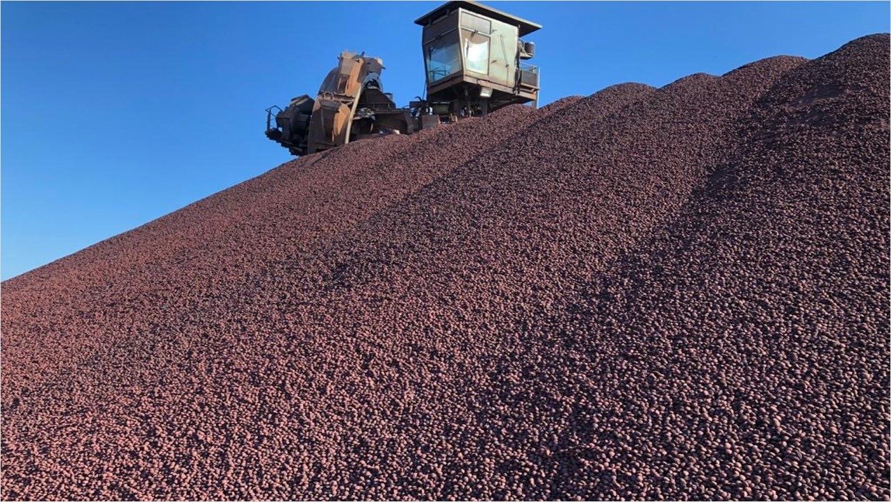 Montanha de minério e no alto uma máquina como uma estrutura de ferro
