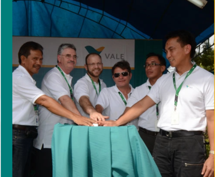 Six employees wear Vale polo shirts and put their hands out in front of them in a team greeting gesture.