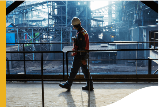 Uniformed and equipped man watches as he walks in construction.