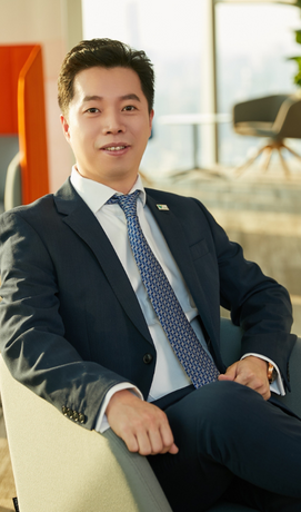 A men is sitting in an office and wears executive clothes