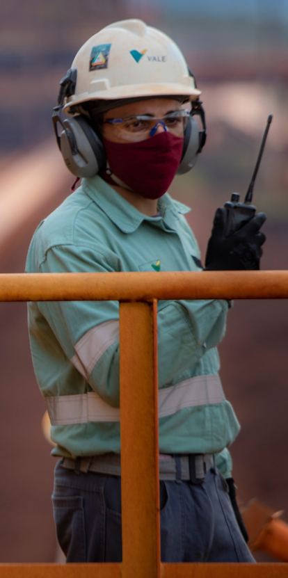 Um grande número de crianças caminha por um local cercada de árvores.