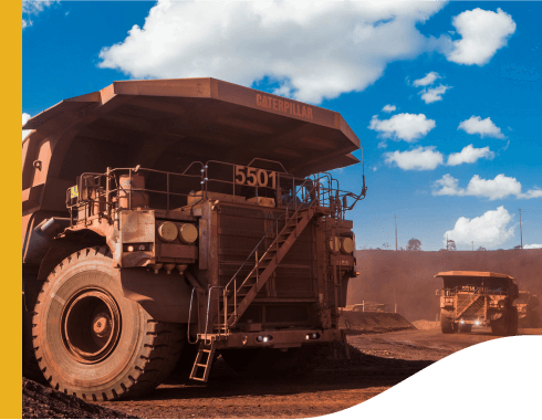 Photo of a huge truck with big wheels filled with dirt in an operation area.