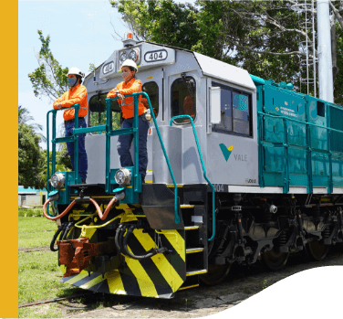 Two Vale employees stand at the front of a train