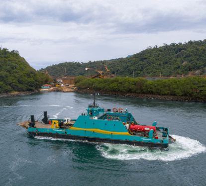 Green and yellow operational boat floating on a big lake.