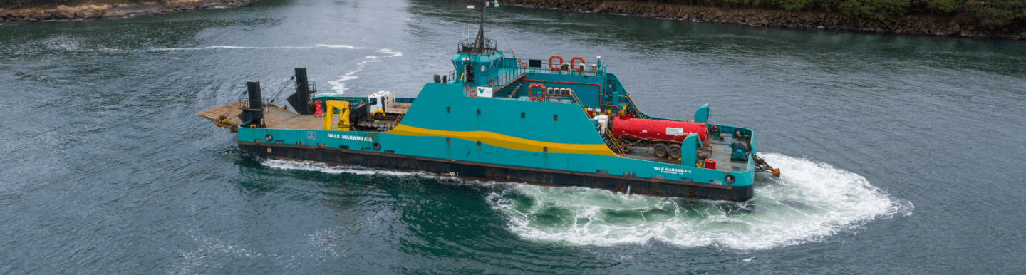 Barco operacional verde e amarelo flutuando em um grande lago.