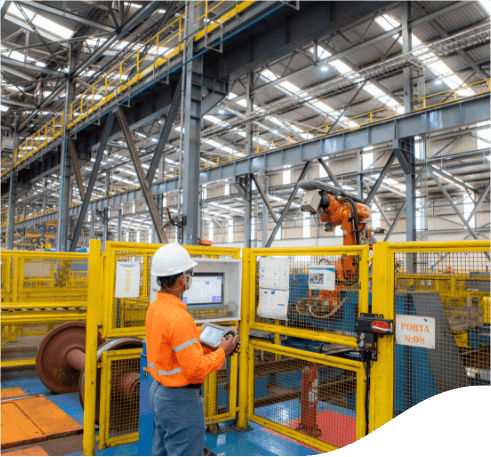 Vale employee in a closed operational space. He is wearing orange uniform, with blue pants and a white helmet.