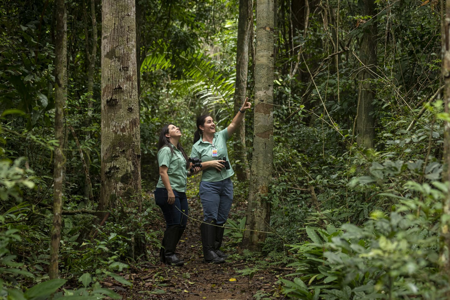 Two employees walk in a place with trees.