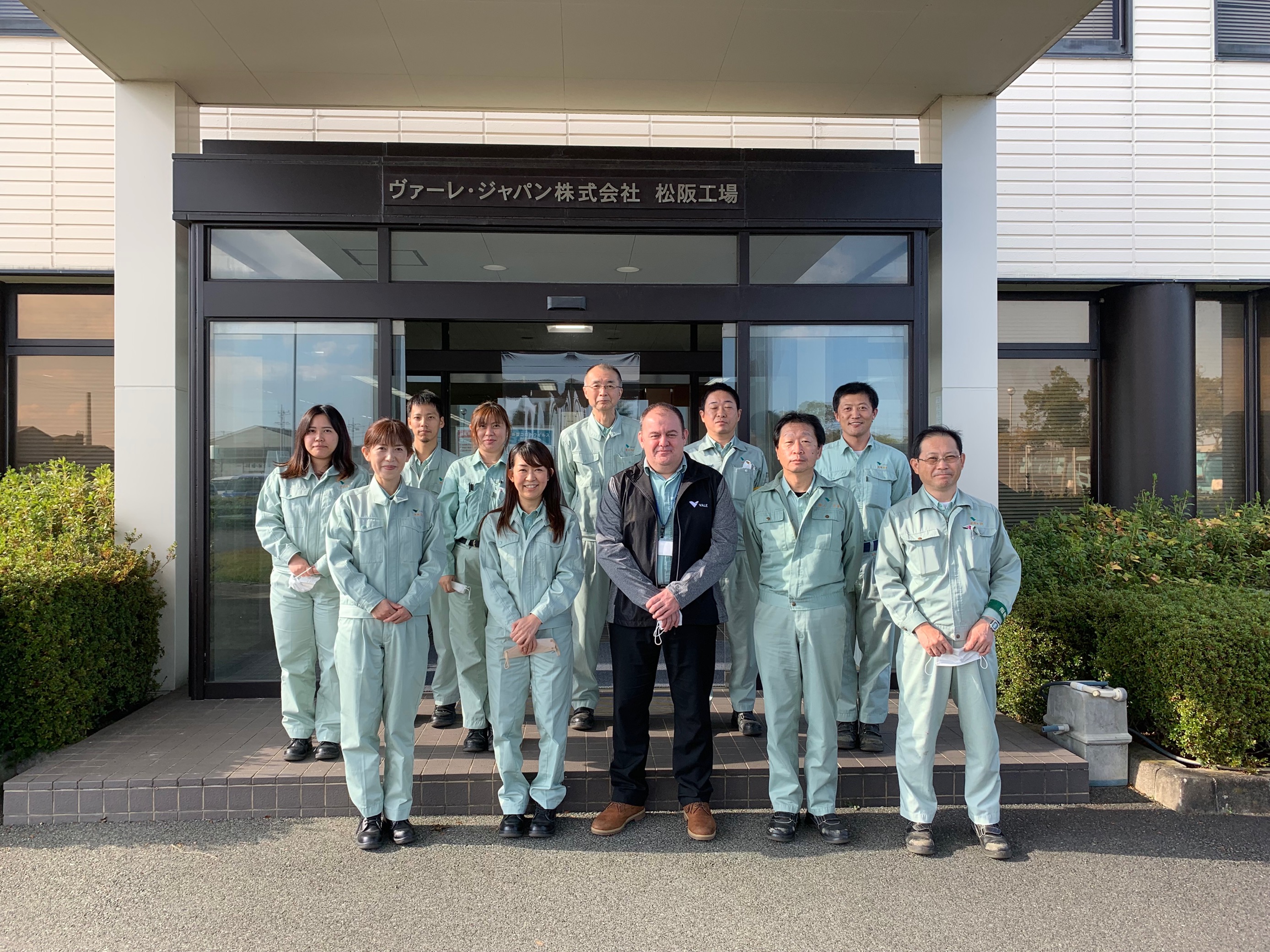 A group of Vale's employees in front of the entrance of a building