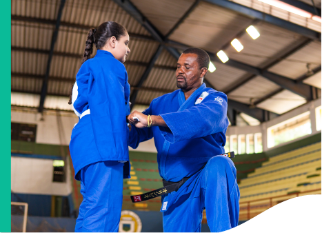 A man and a child are on a mat wearing judo clothes