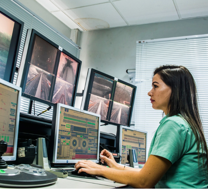 Vale employee sits in a control room with several monitors. She looks closely at one of the screens.