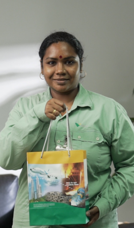 Image of a female employee. She is wearing Vale's uniform and holding a bag.