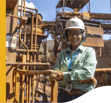 A Vale employee is in a protective area. She is wearing safety equipment such as a hard hat and goggles.