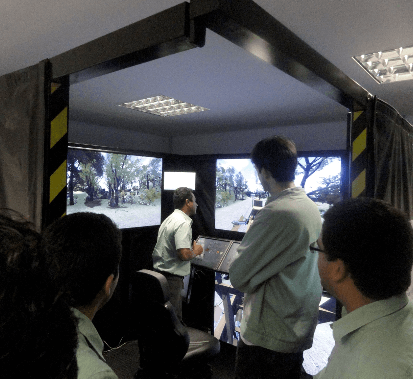 Vale employees standing in a room with two large monitors. Everyone is looking at the screens.