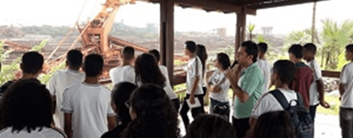 A big group of young people, all in school uniforms, observe Vale external operation, while a company employee accompanies them