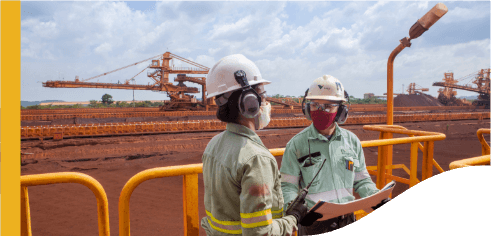 Two Vale employees are in an outside operating area. They are wearing masks.